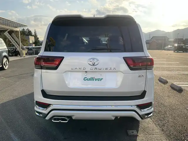 トヨタ ランドクルーザー ZX 滋賀県 2025(令7)年 0.1千km プレシャスホワイトパール ワンオーナー/車検10年9月まで/モデリスタエアロ（フロント、サイド、リア）/3列シート7人乗り/ブラックルーフレール/クールボックス/トノカバー/ムーンルーフ/タイヤ空気圧警報システム/トヨタセーフティセンス/ブラインドスポットモニター/レーダークルーズコントロール/12.3インチディスプレイオーディオプラス/フルセグテレビ、AppleCarPlay、AndroidAuto/JBLプレミアムサウンドシステム/後席11.6インチリアシートエンターテインメント/パノラミックビューモニター/ビルトインETC2.0/ベージュ革シート/前席パワーシート/前席、2列目ベンチレーション付き快適温熱シート/スペアキー有り/取扱説明書、保証書/