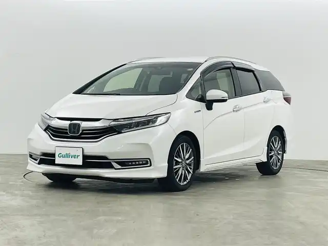 ホンダ シャトル ハイブリッド Z ホンダセンシング 福島県 2022(令4)年 6.5万km プラチナホワイトパール ホンダセンシング/・衝突軽減ブレーキ（CMBS）/・誤発進抑制機能/・路外逸脱抑制機能/・アダプティブクルーズコントロール（ACC）/・車線維持支援システム（LKAS）/・先行車発進お知らせ機能/・標識認識機能/純正ナビ：VXM-215VFEi/・フルセグ/BT/CD/DVD/SD/FM/AM/USB/・バックカメラ/・ビルトインETC/社外前後ドライブレコーダー/革巻きステアリング/・ステアリングスイッチ/・パドルシフト/ハーフレザーシート/・シートヒーター/LEDヘッドライト/・LEDフォグランプ/・オートライト/電動格納ミラー/・ウィンカーミラー/純正フロアマット/ドアバイザー/スマートキー/・プッシュスタート