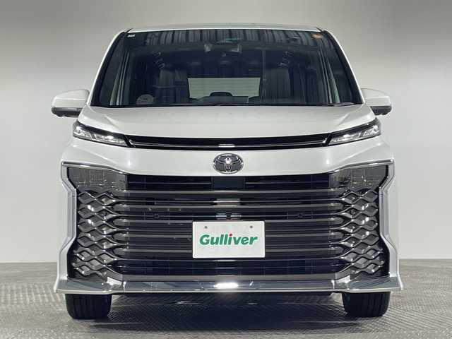 トヨタ ヴォクシー ハイブリッド 神奈川県 2025(令7)年 0.1千km プラチナホワイトパールマイカ ToyotaSafetySense/プリクラッシュセーフティ/緊急時操舵支援/フロントクロストラフィックアラート/レーントレーシングアシスト/レーンディパーチャーアラート/レーダークルーズコントロール/オートマチックハイビームシステム/ロードサインアシスト/ドライバー異常時対応システム/プロアクティブドライビングアシスト/発進遅れ告知機能/パーキングサポートブレーキ/(前後方静止物/後方接近車両)/(周囲静止物/後方歩行者)/アドバンストパーク/パノラミックビューモニター/ECO/PWR+EVモード/８インチディスプレイオーディオ/コネクティッドナビ/DTV/Bluetooth/スマホ連携/HDMI/快適便利パッケージ/ハンズフリーデュアルパワースライドドア/パワーバックドア/ステアリングヒーター/シートヒーター(前席・2列目)/オットマン/デジタルインナーミラー/AC100Vコンセント/ブレーキホールド/取説/ナビ説/保証書/スペアキー