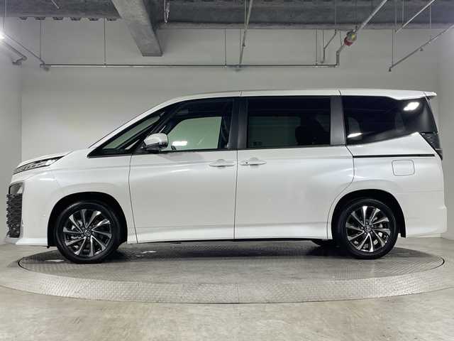 トヨタ ヴォクシー ハイブリッド 神奈川県 2025(令7)年 0.1千km プラチナホワイトパールマイカ ToyotaSafetySense/プリクラッシュセーフティ/緊急時操舵支援/フロントクロストラフィックアラート/レーントレーシングアシスト/レーンディパーチャーアラート/レーダークルーズコントロール/オートマチックハイビームシステム/ロードサインアシスト/ドライバー異常時対応システム/プロアクティブドライビングアシスト/発進遅れ告知機能/パーキングサポートブレーキ/(前後方静止物/後方接近車両)/(周囲静止物/後方歩行者)/アドバンストパーク/パノラミックビューモニター/ECO/PWR+EVモード/８インチディスプレイオーディオ/コネクティッドナビ/DTV/Bluetooth/スマホ連携/HDMI/快適便利パッケージ/ハンズフリーデュアルパワースライドドア/パワーバックドア/ステアリングヒーター/シートヒーター(前席・2列目)/オットマン/デジタルインナーミラー/AC100Vコンセント/ブレーキホールド/取説/ナビ説/保証書/スペアキー