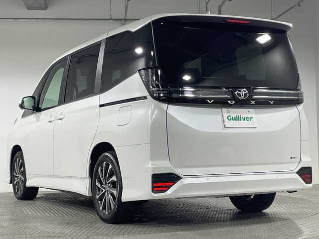 トヨタ ヴォクシー ハイブリッド 神奈川県 2025(令7)年 0.1千km プラチナホワイトパールマイカ ToyotaSafetySense/プリクラッシュセーフティ/緊急時操舵支援/フロントクロストラフィックアラート/レーントレーシングアシスト/レーンディパーチャーアラート/レーダークルーズコントロール/オートマチックハイビームシステム/ロードサインアシスト/ドライバー異常時対応システム/プロアクティブドライビングアシスト/発進遅れ告知機能/パーキングサポートブレーキ/(前後方静止物/後方接近車両)/(周囲静止物/後方歩行者)/アドバンストパーク/パノラミックビューモニター/ECO/PWR+EVモード/８インチディスプレイオーディオ/コネクティッドナビ/DTV/Bluetooth/スマホ連携/HDMI/快適便利パッケージ/ハンズフリーデュアルパワースライドドア/パワーバックドア/ステアリングヒーター/シートヒーター(前席・2列目)/オットマン/デジタルインナーミラー/AC100Vコンセント/ブレーキホールド/取説/ナビ説/保証書/スペアキー