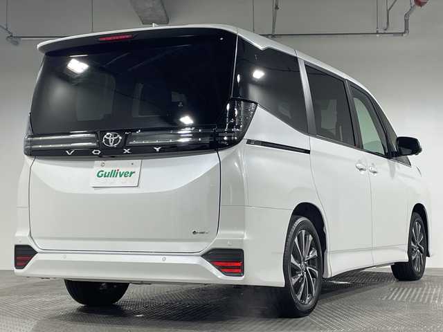 トヨタ ヴォクシー ハイブリッド 神奈川県 2025(令7)年 0.1千km プラチナホワイトパールマイカ ToyotaSafetySense/プリクラッシュセーフティ/緊急時操舵支援/フロントクロストラフィックアラート/レーントレーシングアシスト/レーンディパーチャーアラート/レーダークルーズコントロール/オートマチックハイビームシステム/ロードサインアシスト/ドライバー異常時対応システム/プロアクティブドライビングアシスト/発進遅れ告知機能/パーキングサポートブレーキ/(前後方静止物/後方接近車両)/(周囲静止物/後方歩行者)/アドバンストパーク/パノラミックビューモニター/ECO/PWR+EVモード/８インチディスプレイオーディオ/コネクティッドナビ/DTV/Bluetooth/スマホ連携/HDMI/快適便利パッケージ/ハンズフリーデュアルパワースライドドア/パワーバックドア/ステアリングヒーター/シートヒーター(前席・2列目)/オットマン/デジタルインナーミラー/AC100Vコンセント/ブレーキホールド/取説/ナビ説/保証書/スペアキー