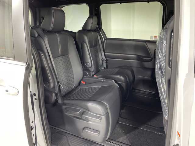 トヨタ ヴォクシー ハイブリッド 神奈川県 2025(令7)年 0.1千km プラチナホワイトパールマイカ ToyotaSafetySense/プリクラッシュセーフティ/緊急時操舵支援/フロントクロストラフィックアラート/レーントレーシングアシスト/レーンディパーチャーアラート/レーダークルーズコントロール/オートマチックハイビームシステム/ロードサインアシスト/ドライバー異常時対応システム/プロアクティブドライビングアシスト/発進遅れ告知機能/パーキングサポートブレーキ/(前後方静止物/後方接近車両)/(周囲静止物/後方歩行者)/アドバンストパーク/パノラミックビューモニター/ECO/PWR+EVモード/８インチディスプレイオーディオ/コネクティッドナビ/DTV/Bluetooth/スマホ連携/HDMI/快適便利パッケージ/ハンズフリーデュアルパワースライドドア/パワーバックドア/ステアリングヒーター/シートヒーター(前席・2列目)/オットマン/デジタルインナーミラー/AC100Vコンセント/ブレーキホールド/取説/ナビ説/保証書/スペアキー