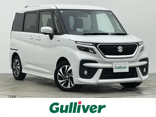 スズキ ソリオ バンディット HV MV 宮城県 2021(令3)年 4.4万km ピュアホワイトP 純正９型ナビ/両側パワースライドドア/全周囲カメラ/ヘッドアップディスプレイ/シートヒーター/パーキングセンサー/アダプティブクルーズコントロール/LEDヘッドライト/セーフティサポート/フルセグTV/スマートフォン連携/ミラー型ドライブレコーダー/CD/DVDプレーヤー/ETC/禁煙車