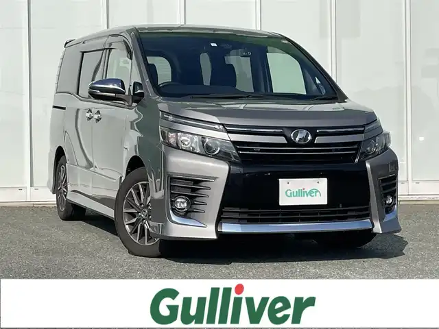 トヨタ ヴォクシー ZS 煌Ⅱ 福岡県 2017(平29)年 3.5万km アイスチタニウムマイカメタリック 純正9インチナビ/（Bカメラ、TV、DVD、CD、Bluetooth、AM、FM）/両側パワースライドドア/12.1インチフリップダウンモニター（V12T-R66C)/ドラレコ前後/ビルトインETC/デュアルエアコン/サンシェード/純正16インチホイール/プリクラッシュ/横滑り防止装置/車線逸脱警報/アイドリングストップ/オートマチックハイビーム/純正マット/ドアバイザー/プリクラッシュ/スマートキー/スペアキー/保証書/取扱説明書