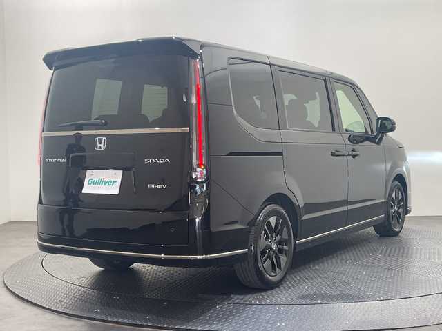 ホンダ ステップワゴン スパーダ eHEV 愛媛県 2025(令7)年 0.1千km クリスタルブラックパール 11.4インチナビHonda CONNECTナビ/Bluetooth/フルセグテレビ/バックカメラ/Honda CONNECT for Gathers/ナビ装着用スペシャルパッケージ/Honda SENSING/ブラインドスポットインフォメーション/パワーテールゲート(メモリー機能付)/2列目オットマン/ハーフレザーシート/運転席＆助手席シートヒーター/トリプルゾーンコントロール/フルオートエアコンディショナー/コンビシート/16インチアルミホイール(SPADA専用)/減速セレクター/全列USBチャージャー/LEDヘッドライト/両側パワースライドドア/スマートキー/追従型クルーズコントロール/前後コーナーセンサー
