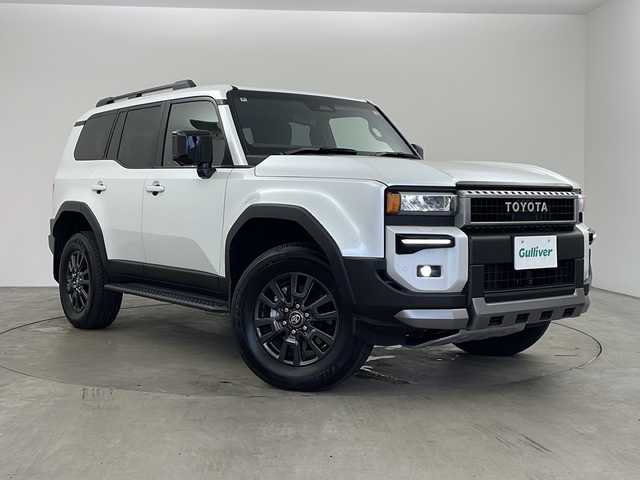 トヨタ ランドクルーザー ２５０ VX 兵庫県 2024(令6)年 0.7万km プラチナホワイトパールマイカ ・サンルーフ/・モデリスタエアロプロテクターキット/・シグネチャーイルミ/・ブラックドアミラーカバー/・純正ナビ＆フルセグ＆BT＆USB＆Miracast＆HDMI/・パノラマミックビューモニター/・革シート/・エアシート/・シートヒーター/・純正ビルトインETC2.0/・ナノイーX/・デジタルインナーミラー/・トヨタセーフティーセンス/・LDA/・BSM/・PCS/・PDA/・クリアランスソナー/・RCTA/・後方車両接近告知/・PCD/・安心降車アシスト/・周辺車両接近時サポート/・RSA/・オートマチックハイビーム/・レーダークルーズコントロール/・ヘッドライトウォッシャー/・パワーバックドア/・寒冷地仕様/・フロントワイパーデアイサー/・リアフォグ/・ステアリングヒーター/・LEDライト/・LEDフォグ/・ブラックドアミラーカバー/・ブラックバックドアガーニッシュ/・ブラックフロントモールセット