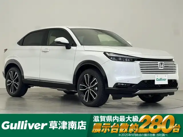 ホンダ ヴェゼル ハイブリッド e:HEV Z 滋賀県 2025(令7)年 0.1千km プラチナホワイトパール 登録済未使用車/純正９インチナビ/(Bluetooth/フルセグTV/USB)/パワーバックドア/レーダークルーズコントロール/バックカメラ/ブラインドスポットモニター/クリアランスソナー/ETC2.0/ワイヤレス充電/ステアリングヒーター/シートヒーター/純正１８インチアルミホイール/オートライト/オートハイビーム/LEDヘッドライト/スペアキー
