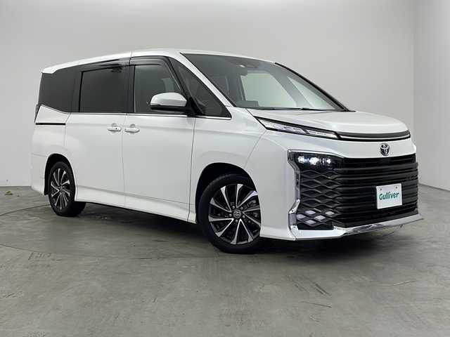 トヨタ ヴォクシー ハイブリッド S－Z 兵庫県 2023(令5)年 1.9万km ホワイトパールクリスタルシャイン ・ワンオーナー車/・純正10.5インチディスプレイオーディオナビ/・Bluetooth/Apple car play/Android Auto/TV/・バックカメラ/・トヨタセーフティセンス/・レーンディバーチャーアラート/・ブラインドスポットモニター/・プリクラッシュセーフティ/・クリアランスソナー/・リヤクロストラフィックアラート/・パーキングサポートブレーキ/・ロードサインアシスト/・安心降車アシスト/・レーダークルーズコントロール/・レーンチェンジアシスト/・ドライバーモニター/・発進遅れ告知/・後退速度抑制/・オートマチックハイビーム/・Advanced Drive/・両側パワースライドドア/・パワーバックドア/・革巻きステアリング/・ステアリングスイッチ/・ハーフレザーシート/・前席シートヒーター/・２列目シートヒーター/・nanoeX/・フロアマット/・純正17インチアルミホイール/・プロジェクター式三眼LEDオートライト/・前方ドライブレコーダー/・ビルドインETC2.0/・W＋サイドエアバッグ/・保証書/・取扱説明書