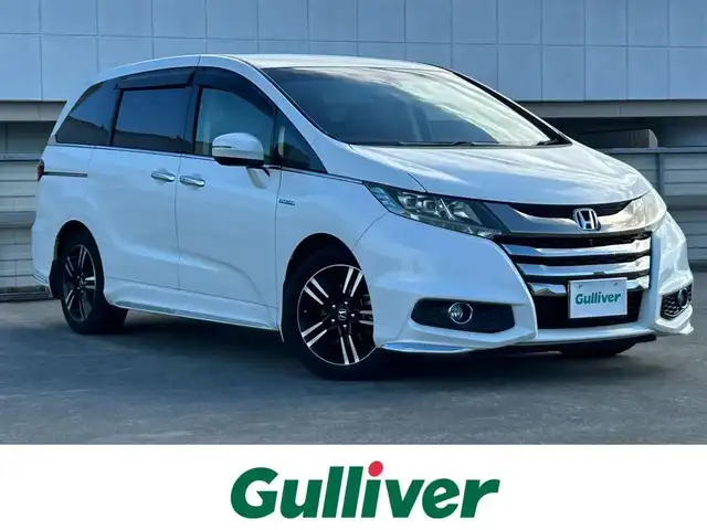 ホンダ オデッセイ ハイブリッド アブソルートセンシングEXパック 静岡県 2016(平28)年 7.4万km ホワイトオーキッドパール ホンダセンシング/1.衝突軽減ブレーキ/2.誤発進抑制機能/3.歩行者事故低減ステアリング/4.路外逸脱抑制機能/5.アダプティブクルーズコントロール/6.車線維持支援システム/7.先行車発進お知らせ機能/8.標識認識機能/9.後方誤発進抑制機能/10.近距離衝軽減ブレーキ/11.オートハイビーム/12.アダプティブドライビングビーム（車速可変照明角度）/13トラフィックジャムアシスト（渋滞運転支援機能）/純正8インチナビ/FM/AM/CD/DVD/Bluetooth/iPod/レーダークルーズコントロール/フリップダウンモニター/両側パワースライドドア/全周囲カメラ/ビルトインETC/前後ドラレコ/ハーフレザーシート/オットマン/ウォークスルー/オートライト