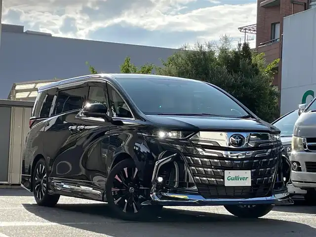 トヨタ アルファードハイブリット エグゼクティブ ラウンジ 東京都 2024(令6)年 0.2万km ブラック ワンオーナー/純正SDナビ/・フルセグTV/・Bluetooth接続/・AM・FM/・DVD再生機能/・HDMI入力端子/ベージュ本革シート/・シートヒーター/・エアーシート/・メモリーパワーシート/・後席オットマン/左右独立ムーンルーフ/トヨタセーフティーセンス/・バックカメラ/・バックカメラ洗浄/・床下透過パノラミックビューモニター/・パーキングサポートブレーキ/・トヨタチームメイト/後席フリップダウンモニター/両側パワースライドドア/二列目エグゼクティブパワーシート/脱着式マルチオペレーションパネル/リフレッシュシート/デジタルインナーミラー/三眼LEDヘッドランプ/ステアリングヒーター/パワーサンシェード/パワーバックドア/照明付きセンターコンソール/JBLプレミアムサウンド/モデリスタエアロ/スマートキー/おくだけ充電/おもてなしスイッチ/ドライブレコーダー/ABS/横滑り防止/ETC2.0t/保証書＆取扱説明書