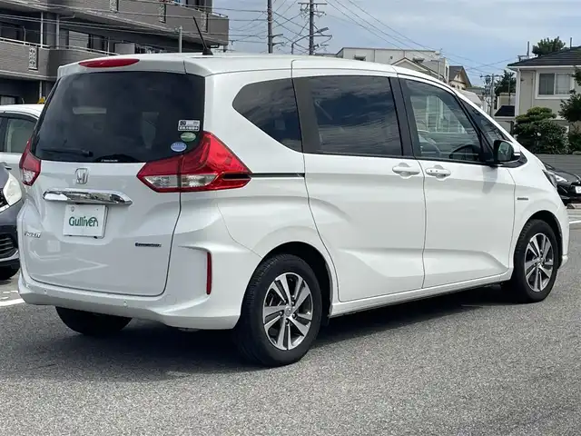 ホンダ フリード ハイブリット G ホンダセンシング 熊本県 2021(令3)年 2.7万km プラチナホワイトパール 純正Ｇａｔｈｅｒｓインターナビゲーション/・地デジＴＶ/・バックカメラ/・FM/AMラジオ/・CD/DVD/・Bluetooth/Cパッケージ/・照明付バニティミラー/・プラズマクラスター付オートエアコン/・シートヒーター【運転席/助手席】/・ロールサンシェード/・コンフォートビューパッケージ/Sパッケージ/・純正１５インチアルミホイール/・革巻きステアリングホイール/・ブラックウォールナット木目調インパネ加飾/・ブラックプライムスムースコンビシート/・シートバックアッパーポケット/ホンダセンシング/・CMBS/・歩行者事故低減ステアリング/・アダプティブクルーズコントロール/・LKAS/・路外逸脱抑制機能/・誤発進抑制機能/・先行車発進お知らせ機能/・標識認識機能/両側パワースライドドア/LEDヘッドランプ/オートライト/アクティブコーナリングランプ/ビルトインETC/SRSエアバック【運転席/助手席】/スマートキーシステム/保証書/取扱説明書/スペアキー１本