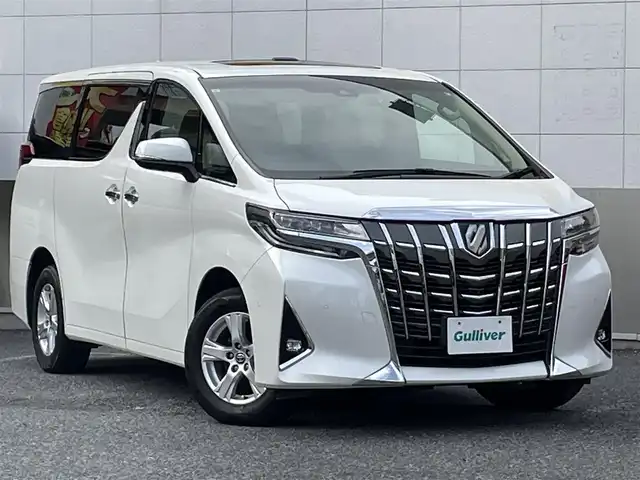 トヨタ アルファードハイブリット X 東京都 2021(令3)年 4.7万km ホワイトパールクリスタルシャイン ワンオーナー/ツインムーンルーフ/JBLプレミアムサウンド/純正10.5インチワイドSDナビ/　DVD/CD/Bluetooth/13.3インチリアエンターテインメント/パノラミックビューモニター/デジタルインナーミラー/ブラインドスポットモニター/前後ドライブレコーダー/両側パワースライドドア/プリクラッシュセーフティ/レーダークルーズコントロール/レーントレーシングアシスト/ロードサインアシスト/LEDヘッドライト/LEDフォグランプ/オートライト/オートマチックハイビーム/ビルトインETC2.0/純正16インチアルミホイール/革巻きステアリングホイール/ステアリングスイッチ/パーキングサポートブレーキ/AC100V/電動オート格納ミラー/ウインカーミラー/プッシュスタート/スマートキー/横すべり防止/純正フロアマット/保証書/取扱説明書