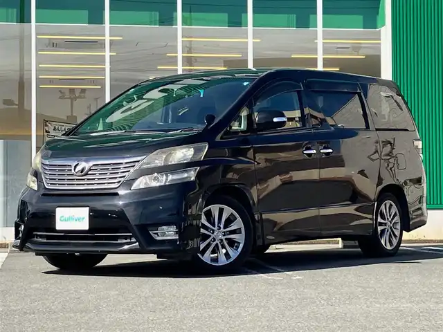 トヨタ ヴェルファイア 2．4Z プラチナセレクションⅡ 静岡県 2011(平23)年 7.4万km 黒 エンジンスタートボタン/パワーステアリング/パワーウィンドウ/スマートキー/Wオートエアコン/スペアキー１本/フリップダウンモニター/ETC/8インチナビ（CD/DVD/BT/フルセグ）/三列シート/オットマン/電動リアゲート/ウォークスルー/フロアマット/両側パワースライドドア/純正アルミホイール/ABS/横滑り防止装置/コーナーセンサー前後/オートライト/W＋サイドエアバック/カーテンエアバック