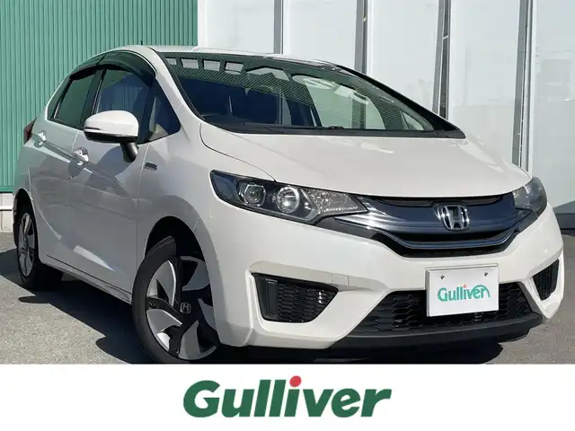 ホンダ フィット ハイブリット Lパッケージ 福岡県 2015(平27)年 7.7万km 白 SDナビ(BT、ワンセグTV、バックカメラ)/ビルトインETC/ハーフレザーシート/純正フロアマット/オートライト/衝突被害軽減システム/スマートキー