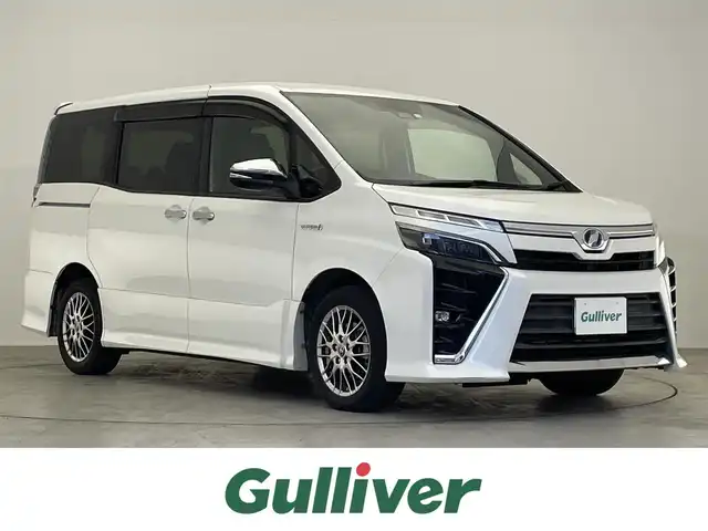 トヨタ ヴォクシー ハイブリッド ZS 煌 滋賀県 2018(平30)年 5.9万km ホワイトパールクリスタルシャイン 禁煙車/純正10型ナビ/Bluetooth／CD／DVD／フルセグTV/バックカメラ/シートヒーター/ＥＴＣ/クルーズコントロール/プリクラッシュセーフティ/レーンディパーチャーアラート/プッシュスタート/両側パワースライドドア/LED/オートライト/オートマチックハイビーム（AHB）/純正アルミホイール