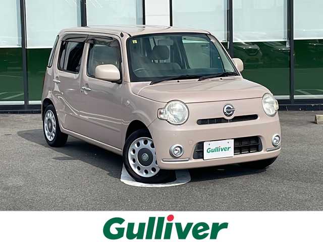 ダイハツ ミラ ココア X 岐阜県 2010(平22)年 7.5万km ライトローズマイカメタリックⅡ 登録時走行距離７４７２６km　/社外７型ＨＤＤナビ　/スマートキー　/ワンオーナー　/ＣＤ・ＤＶＤ・ＭＤ可　/ベンチシート　/フルフラットシート　/アイドリングストップ　/保証書/取扱説明書/記録簿/パワーステアリング/パワーウィンドウ/エアコンAAC/社外フロアマット/ABS/横滑り防止装置　/盗難防止装置　/ハロゲンヘッドライト/エアバッグW