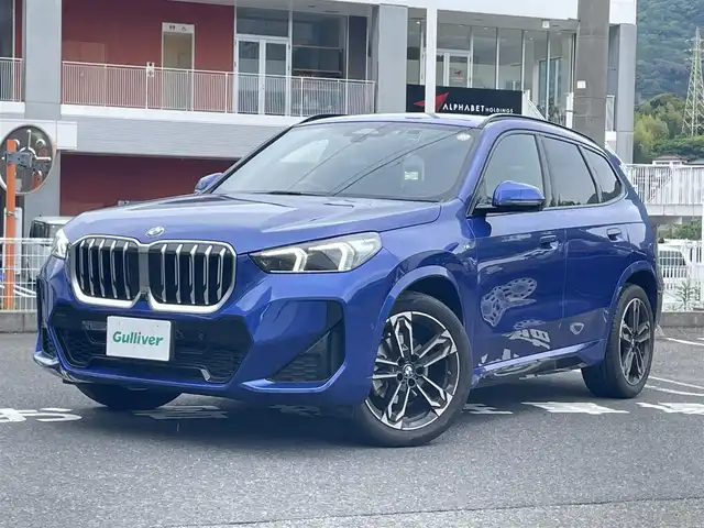 ＢＭＷ ＢＭＷ Ｘ１ 長崎県 2023(令5)年 1.3万km 青 ワンオーナー/車体色ポルティマオブルー(C31)/BMW　iDrive(BT/AM/FM/Spotify/AppleCarPlay/AndroidAuto/NAVI)/ルームミラー内蔵ETC/D+N席パワーシート/D+N席シートヒーター/エアシート/ヘッドアップディスプレイ/革巻きステアリング/ステアリングヒーター/ステアリングスイッチ/追従有りクルーズコントロール/ターボチャージャー搭載車/Assisted Drive Mode/ABS/ダイナミックスタビリティコントロール/アダプティブヘッドライト/レーンチェンジアシスト/アラームシステム/オートライトコントロール/ハイビームアシスト/ヒルディセントコントロール/アダプティブブレーキアシスタント/強化走行ダイナミクス/パークアシスト/制限速度アシスト/スペアキー(スマートキー1本)/カードキー/純正フロアマット/純正19インチアルミホイール/車両/ETC取扱説明書/保証書