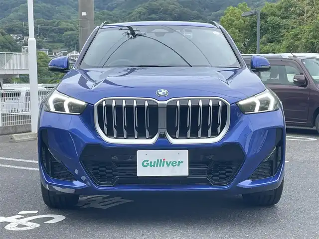 ＢＭＷ ＢＭＷ Ｘ１ 長崎県 2023(令5)年 1.3万km 青 ワンオーナー/車体色ポルティマオブルー(C31)/BMW　iDrive(BT/AM/FM/Spotify/AppleCarPlay/AndroidAuto/NAVI)/ルームミラー内蔵ETC/D+N席パワーシート/D+N席シートヒーター/エアシート/ヘッドアップディスプレイ/革巻きステアリング/ステアリングヒーター/ステアリングスイッチ/追従有りクルーズコントロール/ターボチャージャー搭載車/Assisted Drive Mode/ABS/ダイナミックスタビリティコントロール/アダプティブヘッドライト/レーンチェンジアシスト/アラームシステム/オートライトコントロール/ハイビームアシスト/ヒルディセントコントロール/アダプティブブレーキアシスタント/強化走行ダイナミクス/パークアシスト/制限速度アシスト/スペアキー(スマートキー1本)/カードキー/純正フロアマット/純正19インチアルミホイール/車両/ETC取扱説明書/保証書