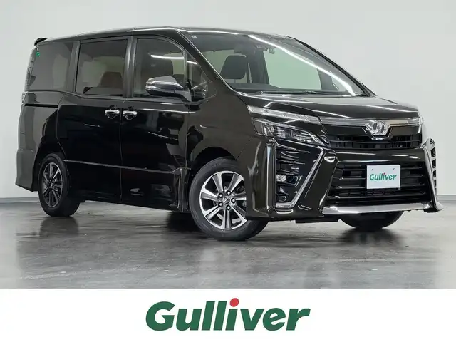 トヨタ ヴォクシー ZS 煌 三重県 2018(平30)年 1.9万km イナズマスパーキングブラックガラスフレーク ガソリン/FF/MTモード付インパネCVT/純正 10インチナビ NSZN-Z66T/（AM/FM/CD/DVD/TV/SD/SDREC/Bluetooth）/バックガイドモニター/両側パワースライドドア/ドライブレコーダー前方/ビルトイン ETC2.0/Toyota Safety Sense/・PCS：プリクラッシュセーフティ/・LDA：レーンディパーチャーアラート/・AHB：オートハイビーム/・横滑り防止装置/など/装備/・【DOP】電子インナーミラー/・クルーズコントロール/・左右独立温度調整＆後席独立調整オートエアコン/・オートライト/・LED ヘッドランプ＆フロントフォグランプ/・ステアリングスイッチ/・プッシュスタート/・充電用USBジャックx2/・純正16inAW/・パワーステアリング/・全ドアパワーウインドウ/・保/取/・スマートキーx2/など