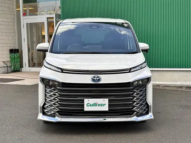 トヨタ ヴォクシー ハイブリッド S－Z 宮城県 2023(令5)年 4.9万km ホワイトパールクリスタルシャイン 快適利便パッケージHigh/・ハンズフリーパワースライドドア（運転席側/助手席側）/・パワーバックドア/・ナノイーX/・ステアリングヒーター/・シートヒーター（2列目左右）/・オットマン（2列目左右）/・角度調整付アームレスト（2列目左右）/ブラインドスポットモニター/＋安心降車アシスト/＋アドバンストドライブ/＋緊急時操舵支援/＋フロントクロストラフィックアラート/＋レーンチェンジアシスト/＋パーキングサポートブレーキ/ドライビングサポートパッケージ/・カラーヘッドアップディスプレイ/・デジタルインナーミラー/＝＝＝/セーフティセンス/・プリクラッシュセーフティ/・レーントレーシングアシスト/・レーダークルーズコントロール/・オートマチックハイビーム/・ロードサインアシスト/・ドライバー異常時対応システム/・プロアクティブドライビングアシスト/・発進遅れ告知機能/パーキングサポートブレーキ/8インチディスプレイオーディオ/バックカメラ/ETC/ドライブレコーダー/AC100V/1500W/シートヒーター