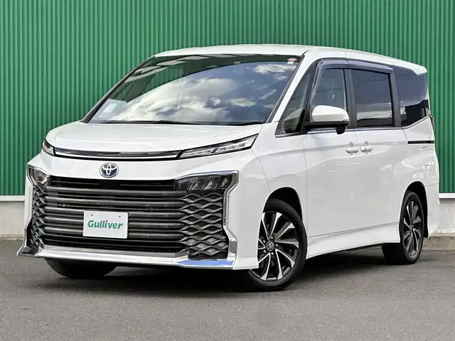 トヨタ ヴォクシー ハイブリッド S－Z 宮城県 2023(令5)年 4.9万km ホワイトパールクリスタルシャイン 快適利便パッケージHigh/・ハンズフリーパワースライドドア（運転席側/助手席側）/・パワーバックドア/・ナノイーX/・ステアリングヒーター/・シートヒーター（2列目左右）/・オットマン（2列目左右）/・角度調整付アームレスト（2列目左右）/ブラインドスポットモニター/＋安心降車アシスト/＋アドバンストドライブ/＋緊急時操舵支援/＋フロントクロストラフィックアラート/＋レーンチェンジアシスト/＋パーキングサポートブレーキ/ドライビングサポートパッケージ/・カラーヘッドアップディスプレイ/・デジタルインナーミラー/＝＝＝/セーフティセンス/・プリクラッシュセーフティ/・レーントレーシングアシスト/・レーダークルーズコントロール/・オートマチックハイビーム/・ロードサインアシスト/・ドライバー異常時対応システム/・プロアクティブドライビングアシスト/・発進遅れ告知機能/パーキングサポートブレーキ/8インチディスプレイオーディオ/バックカメラ/ETC/ドライブレコーダー/AC100V/1500W/シートヒーター