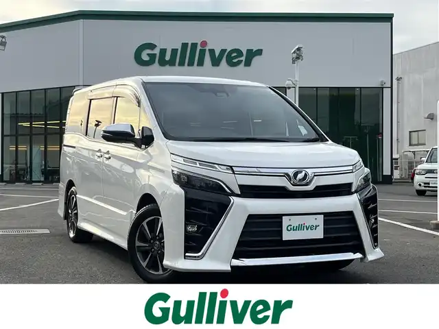 トヨタ ヴォクシー ZS 煌 愛媛県 2018(平30)年 8.9万km ホワイトパールクリスタルシャイン ワンオーナー/登録時走行距離：88485km/純正ナビ/Bluetooth/バックカメラ/後部座席モニター/後部座席エアコン/サンシェード/純正ビルトインETC/横滑り防止装置/レーンキープアシスト/盗難防止装置/衝突軽減システム/LEDヘッドライト/両側パワースライドドア/エンジンスタートボタン/スマートキー/純正フロアマット