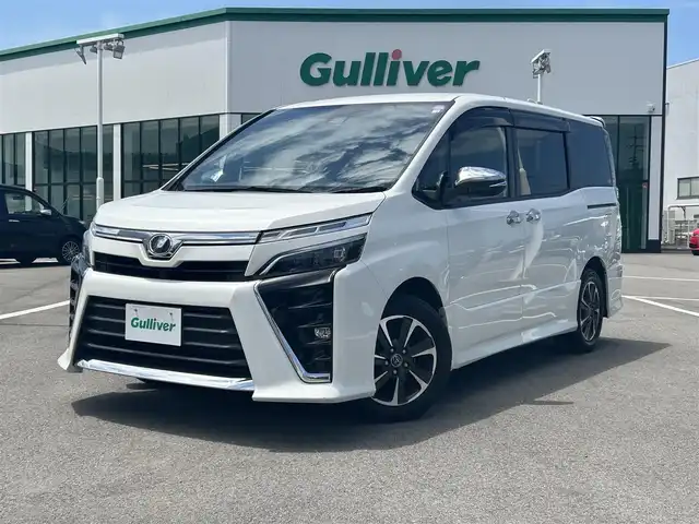 トヨタ ヴォクシー ZS 煌 愛媛県 2018(平30)年 8.9万km ホワイトパールクリスタルシャイン ワンオーナー/登録時走行距離：88485km/純正ナビ/Bluetooth/バックカメラ/後部座席モニター/後部座席エアコン/サンシェード/純正ビルトインETC/横滑り防止装置/レーンキープアシスト/盗難防止装置/衝突軽減システム/LEDヘッドライト/両側パワースライドドア/エンジンスタートボタン/スマートキー/純正フロアマット