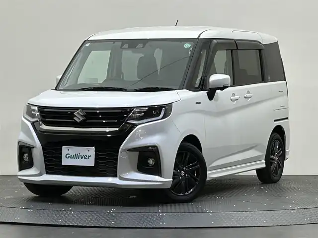 スズキ ソリオ HV SZ 愛媛県 2023(令5)年 0.8万km ピュアホワイトP ・８型ナビ（フルセグＴＶ・ＢＴ・ＣＤＤＶＤ・ＦＭＡＭ・ＳＤ）/・全方位カメラ　/・ＥＴＣ　/・両側電動ドア　/・レーダークルーズコントロール　/・前後コーナーセンサー　/・レーンキープアシスト　/・ＤＮ席シートヒーター　/・ＵＳＢ充電/・衝突軽減/・ヘッドアップディスプレイ