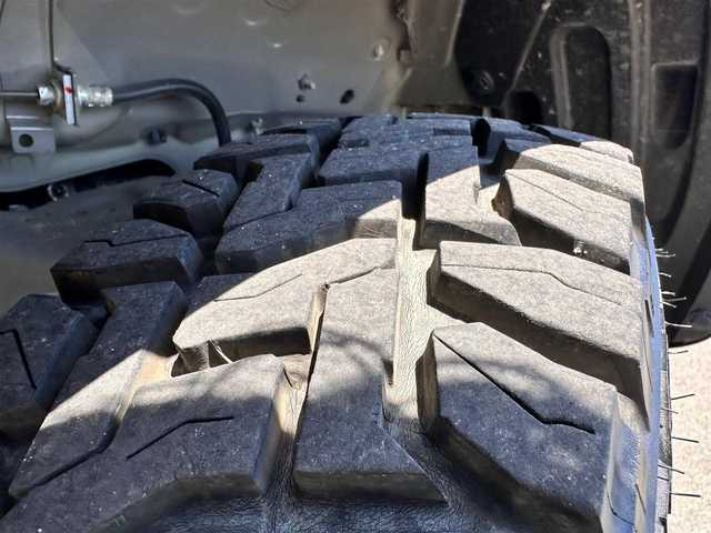 スズキ ジムニー XC 宮城県 2023(令5)年 0.4万km ミディアムグレー ワンオーナー/4WD/社外9インチSDナビ/【CD・DVD・SD・BT・HDMI・フルセグTV】/バックカメラ/純正16インチAW（マッドタイヤ・ホワイトレター）/クルーズコントロール/純正OPグリル/社外HKSマフラー/前席シートヒーター/アイドリングストップ/横滑り防止装置/レーンキープアラート/背面タイヤ/ステアリングスイッチ/電動格納ミラー/オートライト/LEDヘッドライト/LEDフォグ/スマートキーX２/ETC