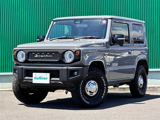 スズキ ジムニー XC 宮城県 2023(令5)年 0.4万km ミディアムグレー ワンオーナー/4WD/社外9インチSDナビ/【CD・DVD・SD・BT・HDMI・フルセグTV】/バックカメラ/純正16インチAW（マッドタイヤ・ホワイトレター）/クルーズコントロール/純正OPグリル/社外HKSマフラー/前席シートヒーター/アイドリングストップ/横滑り防止装置/レーンキープアラート/背面タイヤ/ステアリングスイッチ/電動格納ミラー/オートライト/LEDヘッドライト/LEDフォグ/スマートキーX２/ETC