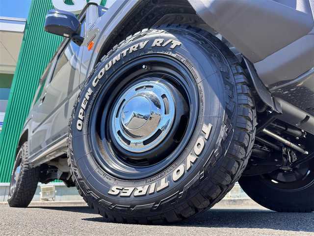 スズキ ジムニー XC 宮城県 2023(令5)年 0.4万km ミディアムグレー ワンオーナー/4WD/社外9インチSDナビ/【CD・DVD・SD・BT・HDMI・フルセグTV】/バックカメラ/純正16インチAW（マッドタイヤ・ホワイトレター）/クルーズコントロール/純正OPグリル/社外HKSマフラー/前席シートヒーター/アイドリングストップ/横滑り防止装置/レーンキープアラート/背面タイヤ/ステアリングスイッチ/電動格納ミラー/オートライト/LEDヘッドライト/LEDフォグ/スマートキーX２/ETC