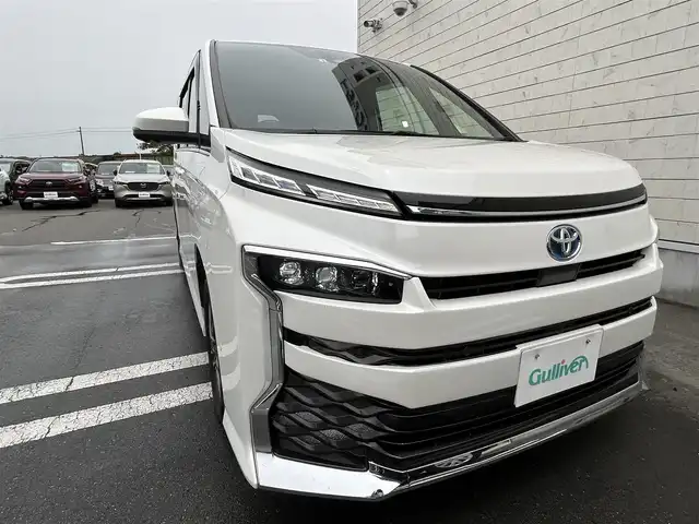 トヨタ ヴォクシー ハイブリッド S－Z 静岡県 2022(令4)年 5.5万km ホワイトパールクリスタルシャイン TOYOTA SAFETY SENSE/・プリクラッシュセーフティ/・レーントレーシングアシスト/・レーダークルーズコントロール/・アダプティブハイビーム/・発進遅れ抑止機能/・レーンチェンジアシスト/純正ナビ/AM FM CD DVD Bluetooth ipod /AppleCarPlay AndroidAuto/ヘッドアップディスプレイ/レザーシート/全席シートヒーター/エアシート/オートブレーキホールド/電動パーキングブレーキ/純正16インチアルミホイール/革巻きステアリング/ステアリングスイッチ/スマートキー＆プッシュスタート/サンシェード/後席カーテン/取扱説明書/フルセグTV　/アラウンドビューモニター/バックモニター/自動駐車システム/ビルトインETC2.0/COMTECドライブレコーダー(HDR361G5)/LEDオートヘッドライト/両側パワースライドドア