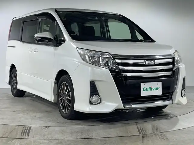 トヨタ ノア Si 福岡県 2015(平27)年 9.9万km ホワイトパールクリスタルシャイン 純正メモリナビ/・CD/DVD/BT/フルセグTV/・バックモニター/純正フリップダウンモニター/両側パワースライドドア/ETC/ドライブレコーダー前後/スマートキー/・スペアキー/・プッシュスタート/オートライト/・ォグランプ/革巻きステアリング/・ステアリングリモコン/純正16インチアルミホイール/純正フロアマット/純正ドアバイザー