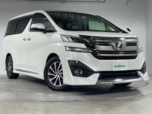 トヨタ ヴェルファイア V 神奈川県 2015(平27)年 7.3万km ホワイトパールクリスタルシャイン モデリスタエアロ【フロント/サイド/リア】/社外10型SDナビゲーション【EX10】/社外フリップダウンモニター/フルセグ　CD DVD　Bluetooth　SD　USB　HDMI/両側電動スライドドア【サンシェード】/パワーバックドア/クルーズコントロール/前後ソナー/木目調/革巻きコンビステアリング/ステアリングスイッチ/合皮/ファブリックコンビシート/前席パワーシート/運転席ポジションメモリー/助手席/2列目オットマン/ビルトインETC/社外前方ドライブレコーダー/電動パーキングブレーキ/オートブレーキホールド/プッシュスタート/スマートキー/LEDヘッド/フォグランプ/オートライト/電格ウインカーミラー