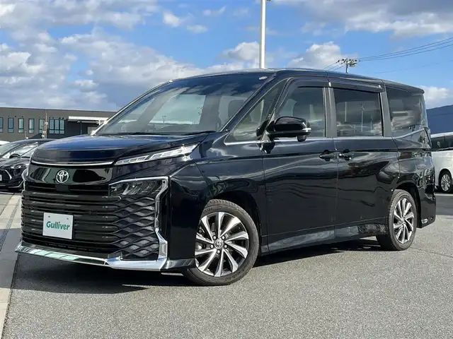 トヨタ ヴォクシー S－Z 奈良県 2023(令5)年 1.9万km アティチュードブラックマイカ 純正10.5インチディスプレイオーディオ/（TV/BT/AppleCarPlay/AndroidAuto)/純正14インチフリップダウンモニター（V14T-R72R）/レーダークルーズコントロール/バックカメラ/前後コーナーセンサー/プリクラッシュセーフティ/レーンキープアシスト/両側パワースライドドア/ハーフレザーシート/前席シートヒーター/後席サンシェード/LEDヘッドライト/ETC2.0/純正17インチAW/保証書/取り扱い説明書/スペアキーX1