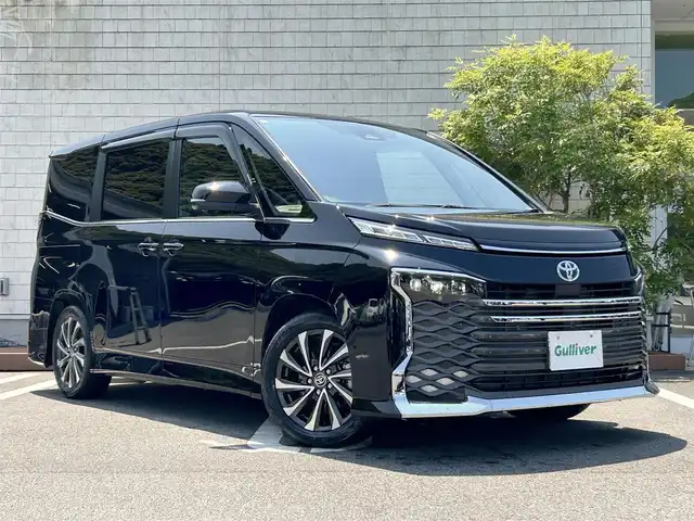 トヨタ ヴォクシー ハイブリッド S－Z 愛媛県 2023(令5)年 1.5万km アティチュードブラックマイカ １０．５型純正ナビ　１４型有機ＥＬフリップダウンモニタ　３６０°カメラ　３眼ＬＥＤヘッドライト　電動パーキングブレーキ　両側電動スライド　シートヒーター　１００Ｖ電源　　ＥＴＣ２．０　パーキングアシスト DVD再生