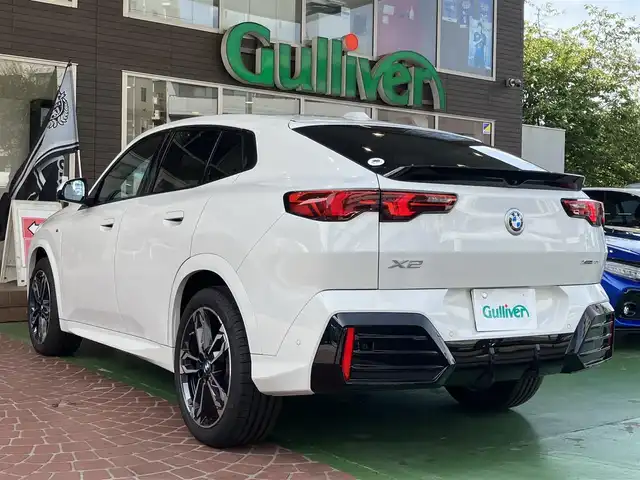 ＢＭＷ ＢＭＷ Ｘ２ xDrive 20i Mスポーツ 神奈川県 2024(令6)年 0.2万km アルピンホワイトⅢ ワンオーナー/新車保証書/取扱説明書/10.7インチHDDナビゲーション/10.25インチマルチディスプレイメーター/　（カープドディスプレイ）/全周囲カメラ/パノラマガラスサンルーフ/ブラックヴェガンザ/アルカンターラコンビシート/パワーシート/ミラー一体型ETC2.0/ハイラインパッケージ/・harman kardon HiFiスピーカーシステム/　（12スピーカー）/ドライビングアシストプロフェッショナル/・高速道路渋滞時ハンズオフアシスト/・アクティブクルーズコントロール/・レーンディパーチャーウォーニング/・レーンチェンジウォーニング/・衝突回避被害軽減ブレーキ/・前車接近警告機能/・クロストラフィックウォーニング/・スピードリミットインフォ/・エマージェンシーストップアシスト/・ステアリング/レーンコントロールアシスト/・レーンキーピングアシスト/・レーンチェンジアシスト/パーキングアシストプラス/・パーキングアシスト/・アクティブパークディスタンスコントロール/・サラウンドビューシステム/・リモート3Dビュー/・リバースアシスト/ストレージパッケージ/パワーバックドア
