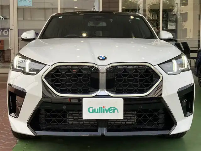 ＢＭＷ ＢＭＷ Ｘ２ xDrive 20i Mスポーツ 神奈川県 2024(令6)年 0.2万km アルピンホワイトⅢ ワンオーナー/新車保証書/取扱説明書/10.7インチHDDナビゲーション/10.25インチマルチディスプレイメーター/　（カープドディスプレイ）/全周囲カメラ/パノラマガラスサンルーフ/ブラックヴェガンザ/アルカンターラコンビシート/パワーシート/ミラー一体型ETC2.0/ハイラインパッケージ/・harman kardon HiFiスピーカーシステム/　（12スピーカー）/ドライビングアシストプロフェッショナル/・高速道路渋滞時ハンズオフアシスト/・アクティブクルーズコントロール/・レーンディパーチャーウォーニング/・レーンチェンジウォーニング/・衝突回避被害軽減ブレーキ/・前車接近警告機能/・クロストラフィックウォーニング/・スピードリミットインフォ/・エマージェンシーストップアシスト/・ステアリング/レーンコントロールアシスト/・レーンキーピングアシスト/・レーンチェンジアシスト/パーキングアシストプラス/・パーキングアシスト/・アクティブパークディスタンスコントロール/・サラウンドビューシステム/・リモート3Dビュー/・リバースアシスト/ストレージパッケージ/パワーバックドア
