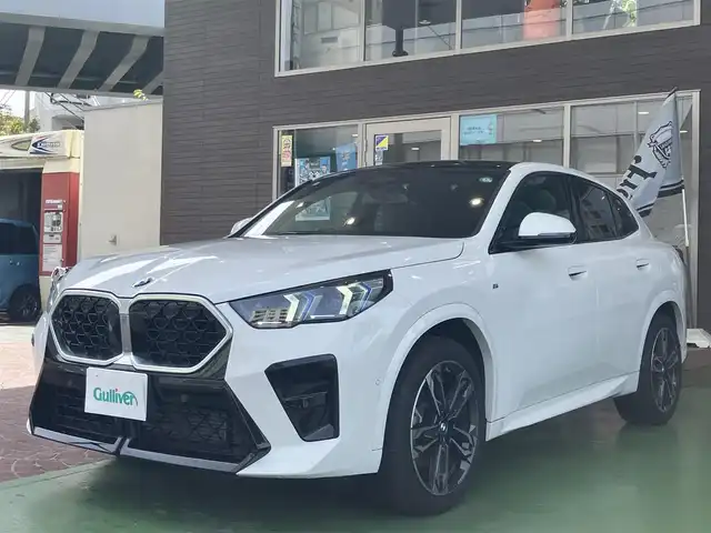 ＢＭＷ ＢＭＷ Ｘ２ xDrive 20i Mスポーツ 神奈川県 2024(令6)年 0.2万km アルピンホワイトⅢ ワンオーナー/新車保証書/取扱説明書/10.7インチHDDナビゲーション/10.25インチマルチディスプレイメーター/　（カープドディスプレイ）/全周囲カメラ/パノラマガラスサンルーフ/ブラックヴェガンザ/アルカンターラコンビシート/パワーシート/ミラー一体型ETC2.0/ハイラインパッケージ/・harman kardon HiFiスピーカーシステム/　（12スピーカー）/ドライビングアシストプロフェッショナル/・高速道路渋滞時ハンズオフアシスト/・アクティブクルーズコントロール/・レーンディパーチャーウォーニング/・レーンチェンジウォーニング/・衝突回避被害軽減ブレーキ/・前車接近警告機能/・クロストラフィックウォーニング/・スピードリミットインフォ/・エマージェンシーストップアシスト/・ステアリング/レーンコントロールアシスト/・レーンキーピングアシスト/・レーンチェンジアシスト/パーキングアシストプラス/・パーキングアシスト/・アクティブパークディスタンスコントロール/・サラウンドビューシステム/・リモート3Dビュー/・リバースアシスト/ストレージパッケージ/パワーバックドア