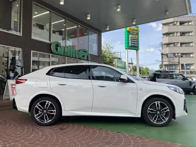 ＢＭＷ ＢＭＷ Ｘ２ xDrive 20i Mスポーツ 神奈川県 2024(令6)年 0.2万km アルピンホワイトⅢ ワンオーナー/新車保証書/取扱説明書/10.7インチHDDナビゲーション/10.25インチマルチディスプレイメーター/　（カープドディスプレイ）/全周囲カメラ/パノラマガラスサンルーフ/ブラックヴェガンザ/アルカンターラコンビシート/パワーシート/ミラー一体型ETC2.0/ハイラインパッケージ/・harman kardon HiFiスピーカーシステム/　（12スピーカー）/ドライビングアシストプロフェッショナル/・高速道路渋滞時ハンズオフアシスト/・アクティブクルーズコントロール/・レーンディパーチャーウォーニング/・レーンチェンジウォーニング/・衝突回避被害軽減ブレーキ/・前車接近警告機能/・クロストラフィックウォーニング/・スピードリミットインフォ/・エマージェンシーストップアシスト/・ステアリング/レーンコントロールアシスト/・レーンキーピングアシスト/・レーンチェンジアシスト/パーキングアシストプラス/・パーキングアシスト/・アクティブパークディスタンスコントロール/・サラウンドビューシステム/・リモート3Dビュー/・リバースアシスト/ストレージパッケージ/パワーバックドア