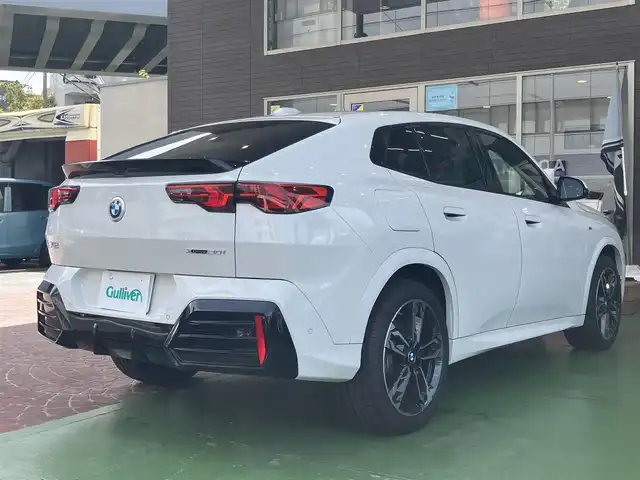 ＢＭＷ ＢＭＷ Ｘ２ xDrive 20i Mスポーツ 神奈川県 2024(令6)年 0.2万km アルピンホワイトⅢ ワンオーナー/新車保証書/取扱説明書/10.7インチHDDナビゲーション/10.25インチマルチディスプレイメーター/　（カープドディスプレイ）/全周囲カメラ/パノラマガラスサンルーフ/ブラックヴェガンザ/アルカンターラコンビシート/パワーシート/ミラー一体型ETC2.0/ハイラインパッケージ/・harman kardon HiFiスピーカーシステム/　（12スピーカー）/ドライビングアシストプロフェッショナル/・高速道路渋滞時ハンズオフアシスト/・アクティブクルーズコントロール/・レーンディパーチャーウォーニング/・レーンチェンジウォーニング/・衝突回避被害軽減ブレーキ/・前車接近警告機能/・クロストラフィックウォーニング/・スピードリミットインフォ/・エマージェンシーストップアシスト/・ステアリング/レーンコントロールアシスト/・レーンキーピングアシスト/・レーンチェンジアシスト/パーキングアシストプラス/・パーキングアシスト/・アクティブパークディスタンスコントロール/・サラウンドビューシステム/・リモート3Dビュー/・リバースアシスト/ストレージパッケージ/パワーバックドア