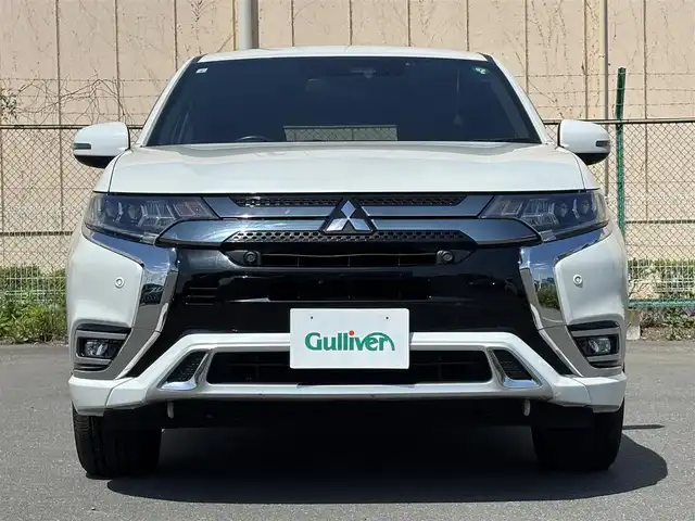 三菱 アウトランダー ＰＨＥＶ G プレミアムパッケージ 東京都 2019(平31)年 11.5万km シルキーホワイト S-AWC(アクティブヨー/アクティブスタビリティコントロール統合制御）/充電機能（普通/急速）/充電口ロック（ドアロック連動）/eアシスト（予防安全技術）/パワーバックドア　/ボディ同色ミラー（電動格納機能/ヒーター/ウィンカー付）/モーフィンブラックインパネ加飾/ブラック天井/ハイコントラストメーター（自発光式アナログメーター/マルチインフォメーションディスプレイ）/シルバー加飾付革巻きステアリングホイール/ステアリングヒーター/ステアリングスイッチ（オーディオ/アダプティブクルーズコントロール）/パドルシフト/SRSエアバック（運転席/助手席/サイド/ニー/カーテン）/左右独立温度調節機能オートエアコン/リアヒーターダクト/パワーシート（運転席/助手席）/シートヒーター（運転席/助手席）/キーレスオペレーションシステム/パワースイッチ/MMCS/６スピーカー/マルチアラウンドモニター/AC電源100V/1500W/リモートコントロール（タイマー充電/空調/車両情報/車両操作）/ディスプレイオーディオ