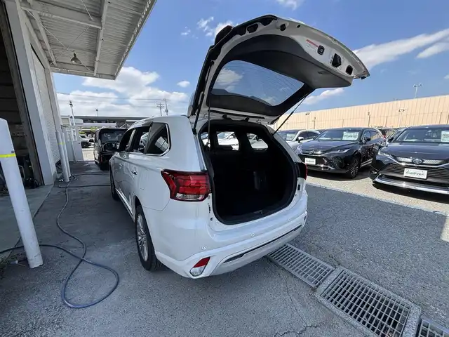 三菱 アウトランダー ＰＨＥＶ G プレミアムパッケージ 東京都 2019(平31)年 11.5万km シルキーホワイト S-AWC(アクティブヨー/アクティブスタビリティコントロール統合制御）/充電機能（普通/急速）/充電口ロック（ドアロック連動）/eアシスト（予防安全技術）/パワーバックドア　/ボディ同色ミラー（電動格納機能/ヒーター/ウィンカー付）/モーフィンブラックインパネ加飾/ブラック天井/ハイコントラストメーター（自発光式アナログメーター/マルチインフォメーションディスプレイ）/シルバー加飾付革巻きステアリングホイール/ステアリングヒーター/ステアリングスイッチ（オーディオ/アダプティブクルーズコントロール）/パドルシフト/SRSエアバック（運転席/助手席/サイド/ニー/カーテン）/左右独立温度調節機能オートエアコン/リアヒーターダクト/パワーシート（運転席/助手席）/シートヒーター（運転席/助手席）/キーレスオペレーションシステム/パワースイッチ/MMCS/６スピーカー/マルチアラウンドモニター/AC電源100V/1500W/リモートコントロール（タイマー充電/空調/車両情報/車両操作）/ディスプレイオーディオ