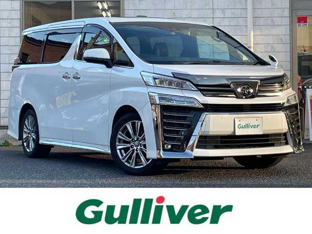 トヨタ ヴェルファイア Z ゴールデンアイズ 福岡県 2020(令2)年 5.5万km ホワイトパールクリスタルシャイン ツインムーンルーフ/純正12.1インチフリップダウンモニター【V12T-R68C】/純正9インチディスプレイオーディオ/　(AM/FM/CD/DVD/Bluetooth/Miracast/フルセグTV/ナビ有り)/バックカメラ/トヨタセーフティセンス/・プリクラッシュセーフティ/・レーントレーシングアシスト/・ロードサインアシスト/・レーダークルーズコントロール/・先行車発進告知/・ブラインドスポットモニター/・クリアランスソナー/・リヤクロストラフィックアラート/・パーキングサポートブレーキ/オートライト/オートマチックハイビーム/横滑り防止/両側パワースライドドア/純正18インチアルミホイール/パワーバックドア/デジタルインナーミラー/黒色ハーフレザーシート/オットマン(2列目)/革巻きステアリング/ステアリングスイッチ/コムテック前後ドライブレコーダー【DC-DR652】/純正ビルトインETC/純正フロアマット/ナノイー/USB端子/アクセサリーソケット/100V電源/ISOFIX/スペアキー×1/保証書/取扱説明書/ナビ取扱説明書