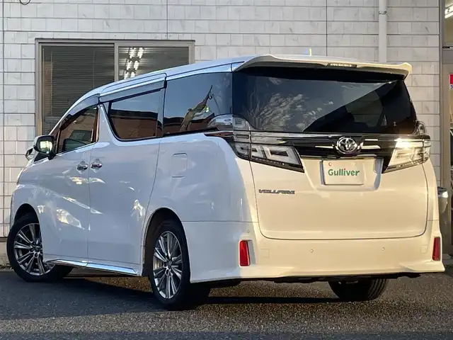 トヨタ ヴェルファイア Z ゴールデンアイズ 福岡県 2020(令2)年 5.5万km ホワイトパールクリスタルシャイン ツインムーンルーフ/純正12.1インチフリップダウンモニター【V12T-R68C】/純正9インチディスプレイオーディオ/　(AM/FM/CD/DVD/Bluetooth/Miracast/フルセグTV/ナビ有り)/バックカメラ/トヨタセーフティセンス/・プリクラッシュセーフティ/・レーントレーシングアシスト/・ロードサインアシスト/・レーダークルーズコントロール/・先行車発進告知/・ブラインドスポットモニター/・クリアランスソナー/・リヤクロストラフィックアラート/・パーキングサポートブレーキ/オートライト/オートマチックハイビーム/横滑り防止/両側パワースライドドア/純正18インチアルミホイール/パワーバックドア/デジタルインナーミラー/黒色ハーフレザーシート/オットマン(2列目)/革巻きステアリング/ステアリングスイッチ/コムテック前後ドライブレコーダー【DC-DR652】/純正ビルトインETC/純正フロアマット/ナノイー/USB端子/アクセサリーソケット/100V電源/ISOFIX/スペアキー×1/保証書/取扱説明書/ナビ取扱説明書