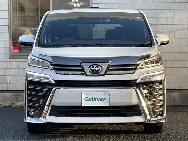 トヨタ ヴェルファイア Z ゴールデンアイズ 福岡県 2020(令2)年 5.5万km ホワイトパールクリスタルシャイン ツインムーンルーフ/純正12.1インチフリップダウンモニター【V12T-R68C】/純正9インチディスプレイオーディオ/　(AM/FM/CD/DVD/Bluetooth/Miracast/フルセグTV/ナビ有り)/バックカメラ/トヨタセーフティセンス/・プリクラッシュセーフティ/・レーントレーシングアシスト/・ロードサインアシスト/・レーダークルーズコントロール/・先行車発進告知/・ブラインドスポットモニター/・クリアランスソナー/・リヤクロストラフィックアラート/・パーキングサポートブレーキ/オートライト/オートマチックハイビーム/横滑り防止/両側パワースライドドア/純正18インチアルミホイール/パワーバックドア/デジタルインナーミラー/黒色ハーフレザーシート/オットマン(2列目)/革巻きステアリング/ステアリングスイッチ/コムテック前後ドライブレコーダー【DC-DR652】/純正ビルトインETC/純正フロアマット/ナノイー/USB端子/アクセサリーソケット/100V電源/ISOFIX/スペアキー×1/保証書/取扱説明書/ナビ取扱説明書