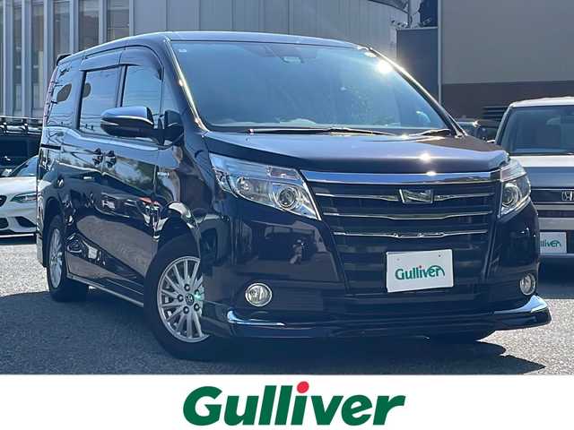 トヨタ ノア ハイブリッド G 大阪府 2016(平28)年 4万km ボルドーマイカメタリック ワンオーナー/純正メモリナビ/・AM/FM/CD/DVD/Bluetooth/・フルセグテレビ/ETC/ドライブレコーダー/クルーズコントロール/衝突軽減ブレーキ/レーンキープアシスト/横滑り防止装置/盗難防止装置/両側パワースライド/コーナーセンサー/シートヒーター（D席+N席）/LEDヘッドライト/オートマチックハイビーム/オートライト/オートエアコン/プッシュスタートボタン/スマートキー×2/ステアリングリモコン/革巻きステアリング/純正15インチアルミホイール/12V充電器/純正フロアマット/ドアバイザー/保証書/取扱説明書