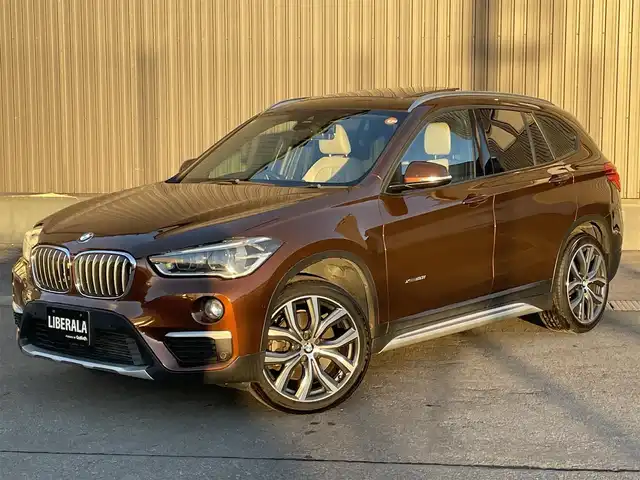 ＢＭＷ Ｘ１ xDrive 20i Xライン 青森県 2016(平28)年 5.5万km グレー 純正HDDナビ/(CD/DVD/Bluetooth/AM/FM)/USB入力端子/バックカメラ/電動パノラマサンルーフ/ドライビングアシスト/・車線逸脱警報システム/・衝突回避/・衝突軽減ブレーキ/パーキングアシスト/クルーズコントロール/LEDヘッドライト/オートライト/レザーシート/シートヒーター/パークディスタンスコントロール/純正19インチAW/オートマチックデールゲート/ドライブレコーダー/ミラー一体型ETC/ルーフレール/スマートキー/スペアキー/純正フロアマット/チェスナットブロンズカラー(C29)