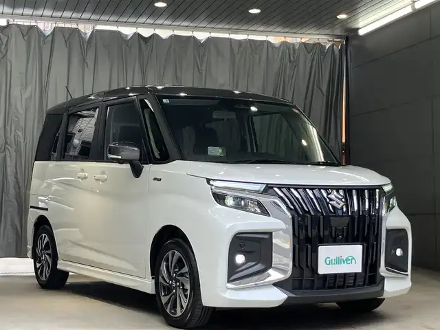 スズキ ソリオ バンディット HV MV 東京都 2025(令7)年 0.4万km ピュアホワイトパール/ガンメタリック2トーン 4WD/ワンオーナー/2トーンルーフ仕様/セーフティサポート/・デュアルセンサーサポート2/・誤発進抑制機能/・後方誤発進抑制機能/・パーキングセンサー/・低速時ブレーキサポート（前進・後退）/・車線逸脱抑制機能/・車線逸脱警告機能/・ふらつき警告機能/・標識認識機能/・ハイビームアシスト/・ブラインドスポットモニター/・アクティブクルーズコントロール/両側パワースライドドア/純正9インチナビ/・地デジ/DVD/CD/USBソケット/全方位カメラ/AppleCarPlay Android auto/プッシュスタート/ヘッドアップディスプレイ/シートヒーター /保証書・取扱説明書・スペアキー